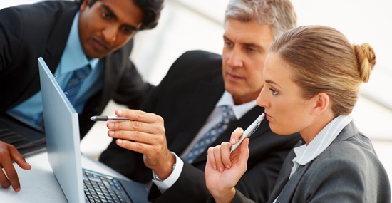 Successful group of business colleagues working on a laptop